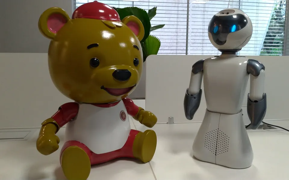 Beo dressed as a bear mascot next to the standard Beo