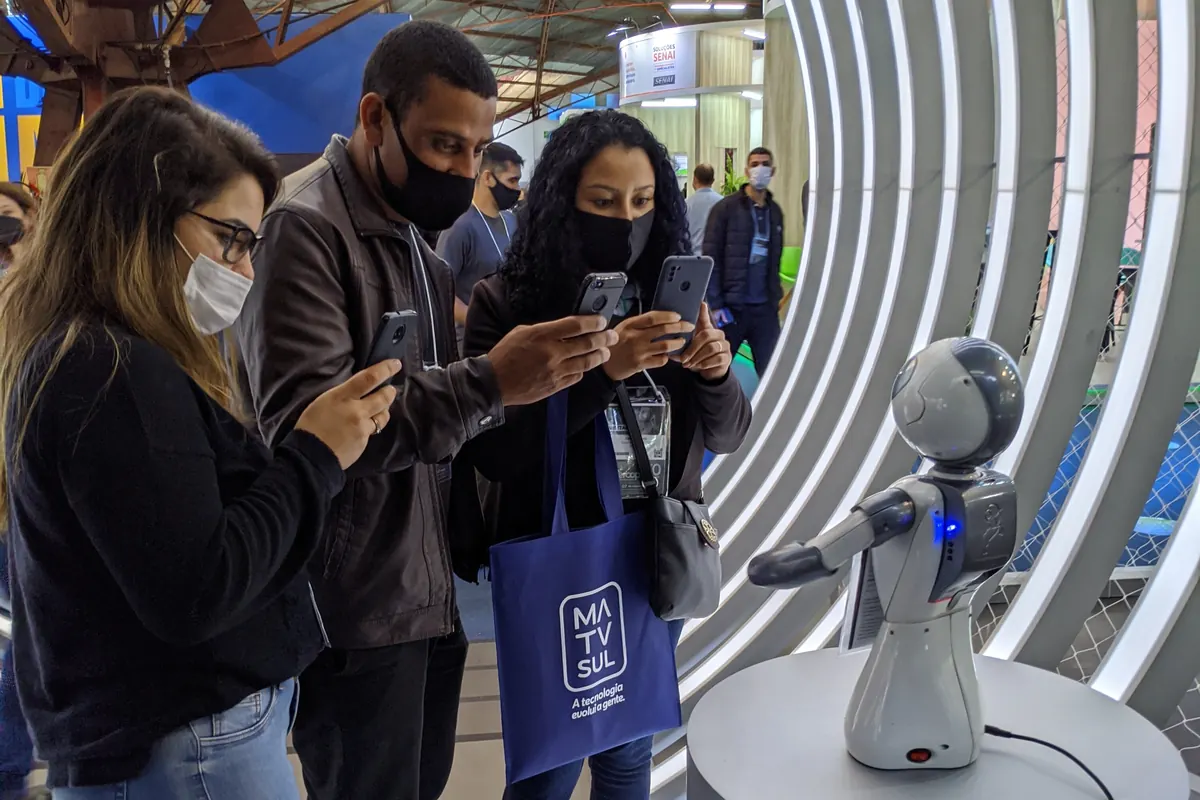 Visitors filming Beo on their phones at a trade show